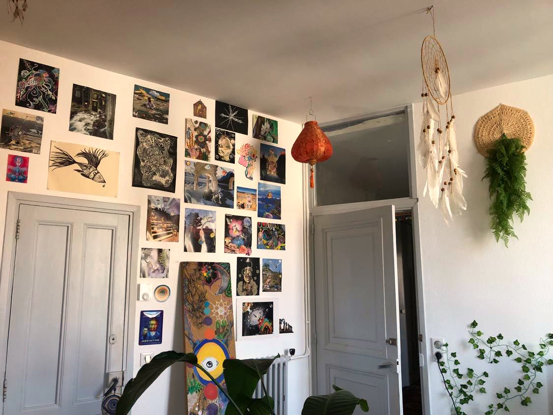 Décoration hippie d'un salon avec de affiches surréaliste, de l'art psychédélique et un attrape rêve au plafond